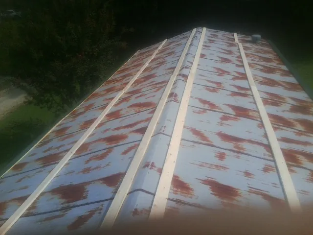 Rusted metal roof panels with new wood purlins before replacement — Storm Damage Roof Repair in North Truro by Roofing Brothers