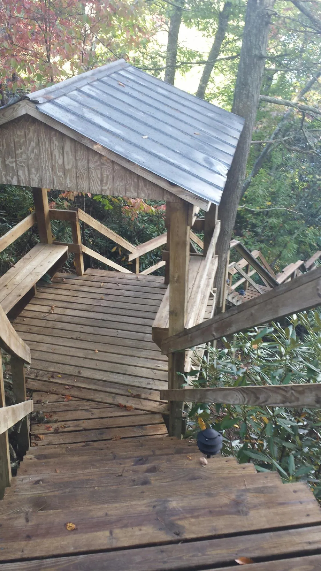 Metal roofed shelter over wooden steps on a wooded walkway — Skylight Repair & Installation work by our crew in North Truro