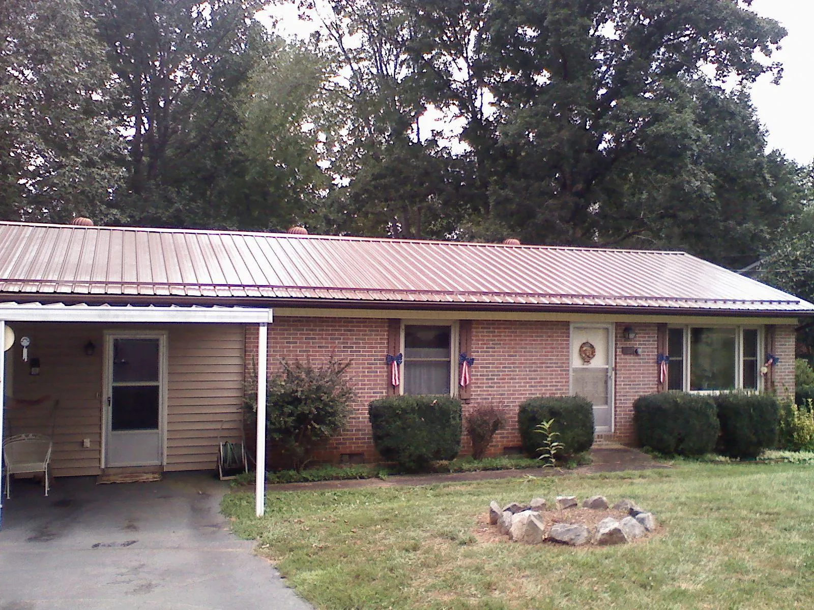 Bronze metal roof and carport on a brick ranch home — Roof Repair work by our crew in North Truro